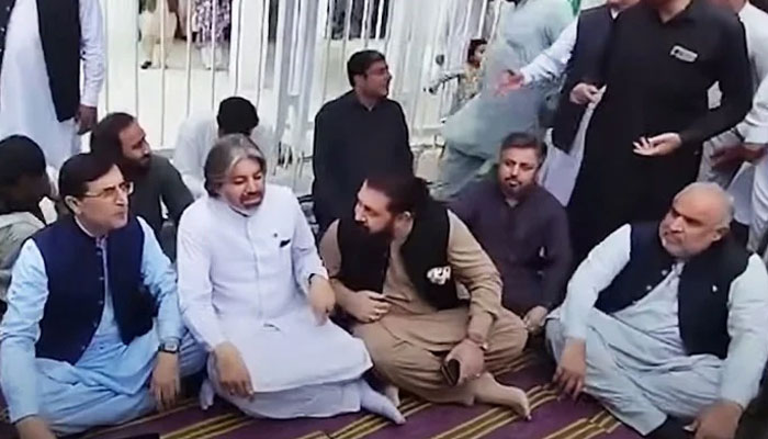 PTI Chairman Barrister Gohar Ali Khan (left) sitting at the hunger strike camp outside Parliament House, Islamabad, alongside other party leaders on July 23, 2024. — Screengrab via Geo News