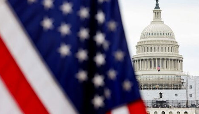 A representational image of US Capitol Hill in Washington, DC alongside silhouette of a US flag. —Reuters/File