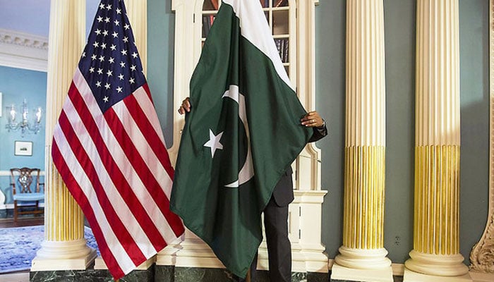 A State Department contractor adjust Pakistan national flag before a meeting at the State Department in Washington. — Reuters/File