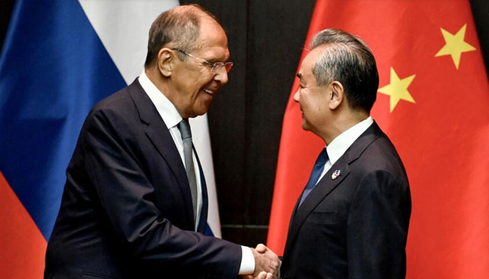 Chinas Foreign Minister Wang Yi (right) shakes hands with Russias Foreign Minister Sergei Lavrov during a ministerial meeting on the sidelines of ASEAN talks in Vientiane. — AFP/File