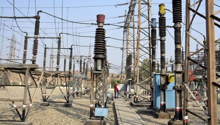 Pakistani technicians work at a power grid station in Faisalabad .— AFP/File