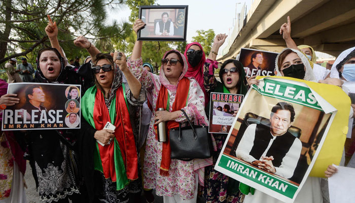 Activists and supporters of the PTI party hold posters of party founderImran Khan as they take part in a demonstration demanding his release in Peshawar on July 26, 2024. — AFP