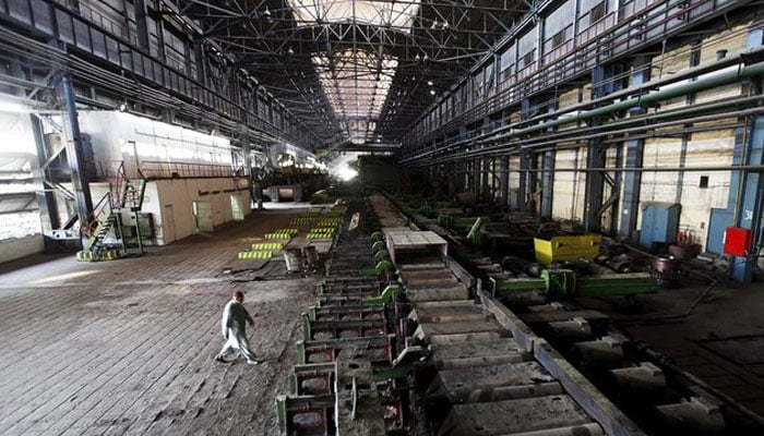 A man walks past machines at the hot strip mill department of the Pakistan Steel Mills (PSM) on the outskirts of Karachi on February 8, 2016. — Reuters