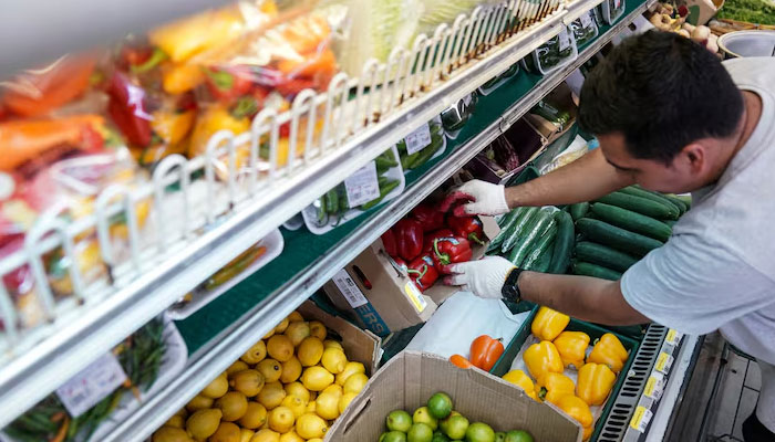 A man arranges vegetables at a supermarket in Washington, D.C., US on  August 19, 2022. — Reuters