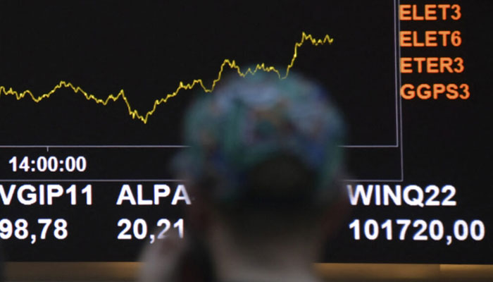 A man looks at a chart on display in an electronic board at the digital trade on June 17, 2022. — AFP