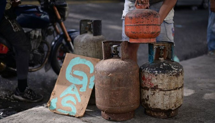 A man stacks a gas cylinder in a street stall on July 20, 2024. — Reuters