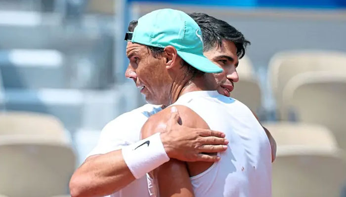 Spanish tennis player Carlos Alcaraz (left) hugs his felloy countryman and tennis veteran Rafael Nadal (on July 24, 2024. — Reuters