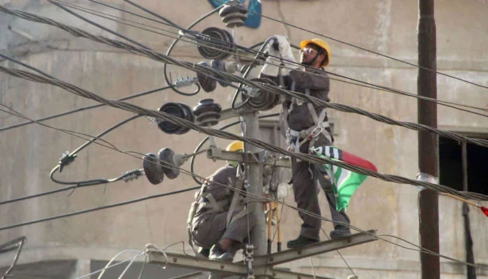 Workers repair the high voltage wires on a pole on February 20, 2024. — Online