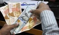 Rupee posts modest gains against dollar in interbank, falls slightly in open market