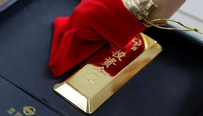 A sales assistant displays a 1000 gram gold bar as an investment for a customer at Jewelry store, in Beijing, China, August 6, 2019. — Reuters/file