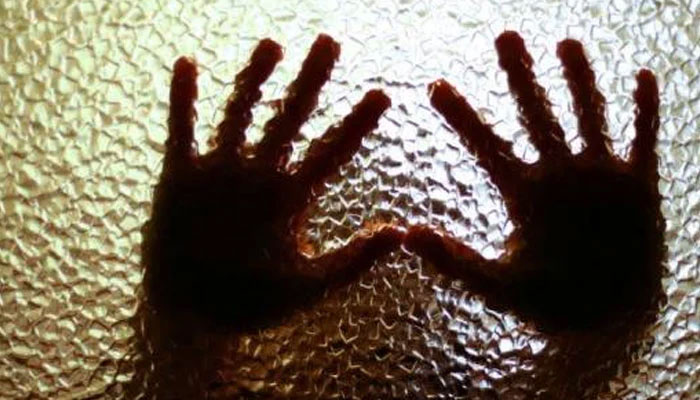 Representational image of a person pressing their hands against the glass as a gesture of protest against rape, harassment. — AFP/File