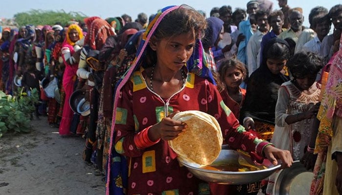 In this image, people stand in queues to receive free food. — AFP/file