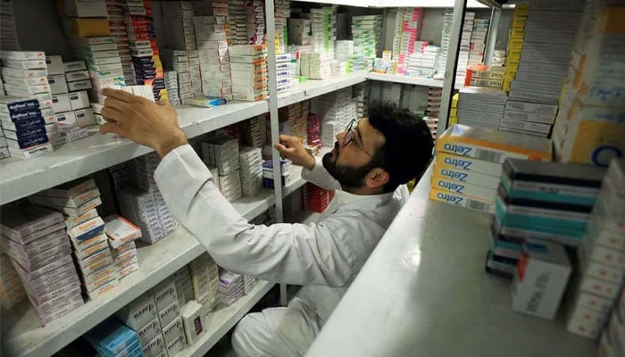 A man sorts and arranges medicine packs at a pharmacy store in Peshawar. — Reuters/File