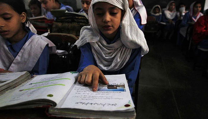 In this image a student reading a book in a classroom. — Reuters/File