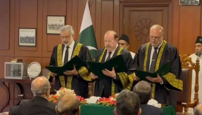 CJP Qazi Faez Isa (left) administers oath to Justices (retd) Sardar Tariq Masood (centre) and Mazhar Alam Miankhel as Supreme Courts ad hoc judges in Islamabad on July 29, 2024. — Screengrab/GeoNews