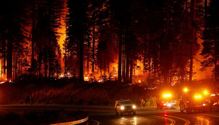 A vehicle passes firefighters standing by the road as the Park Fire burns, near Jonesville, California, US, July 28, 2024. — Reuters