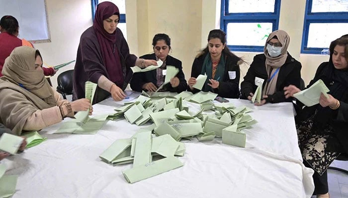 Polling officials count votes at a polling station in Islamabad. — APP/File