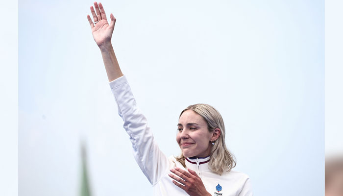 Frances gold medallist  Cassandre Beaugrand reacts on the podium during the victory ceremony for the womens individual triathlon at the Paris 2024 Olympic Games in Paris on July 31, 2024. — AFP