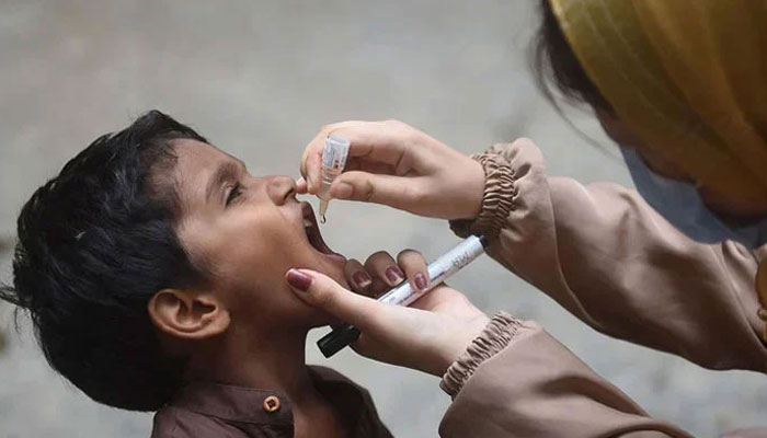 A woman administering polio drops to a child on August 7, 2023. — AFP