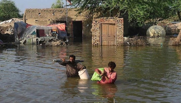 Flood affected people carry belongings out from their flooded home in Shikarpur in Sindh on August 31, 2022. — AFP/File