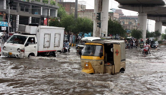 Due to heavy monsoon rains in Chaubarji area of ​​Lahore, passengers and vehicles are facing difficulties in transportation due to poor sewage system on August 1, 2024. — PPI