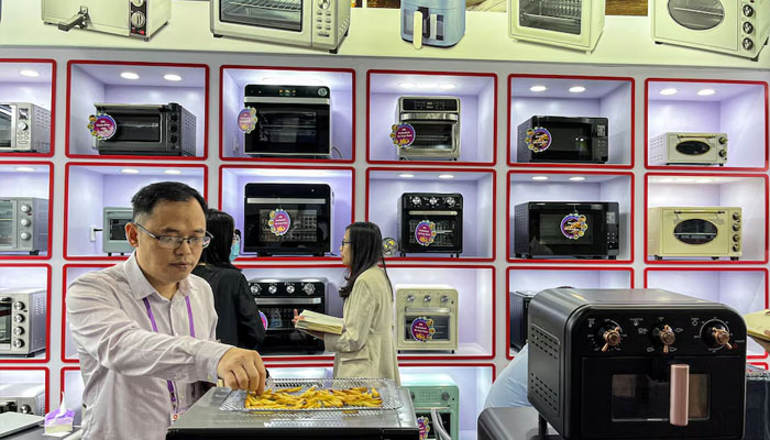 A staff member attends to visitors at an oven retailer at the China Import and Export Fair, also known as Canton Fair, in Guangzhou, Guangdong province, China April 16, 2023. — Reuters