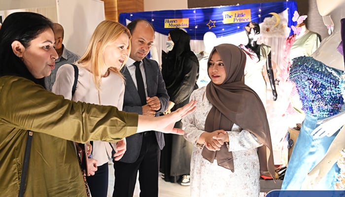 Ambassador of Bulgaria to Pakistan Irina Gancheva and Educational Counselor Mehmet Toyran, Embassy of Turkey inspecting the clothes made by the students at Iqra University Fashion Theses Display. — Facebook @IUIsbCampus/file