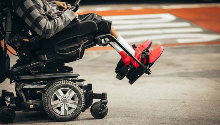 A representational image of a person using an electric wheelchair. — Unsplash/File