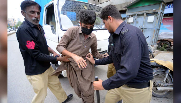 Police officials arrest a protester of Baloch Yakjehti Committee near Karachi Press Club on July 31, 2024. — PPI