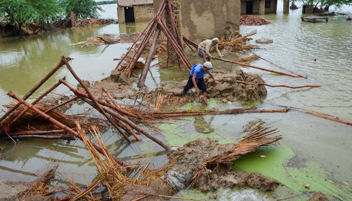 A representational image showing people going through debris of a house that collapsed due to floods. — Reuters/File