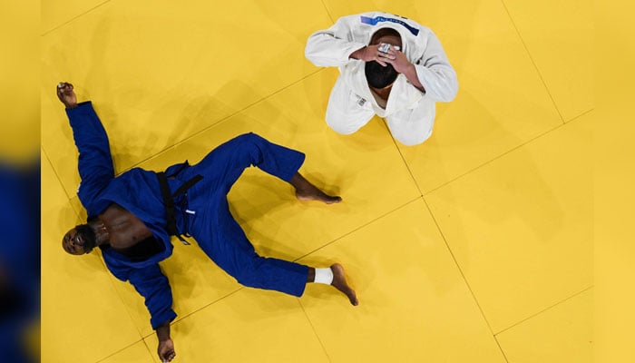 An overview shows Japans Tatsuru Saito reacting after being deeated by Frances Teddy Riner (Blue) in the judo mixed team gold medal bout between Japan and France at the Paris 2024 Olympic Games in Paris on August 3, 2024. — AFP