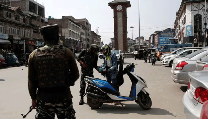 A representational image showing Indian security personnel inspecting a motorcycle rider in the  Indian Illegally Occupied Jammu and Kashmir (IIOJK). — Reuters/File