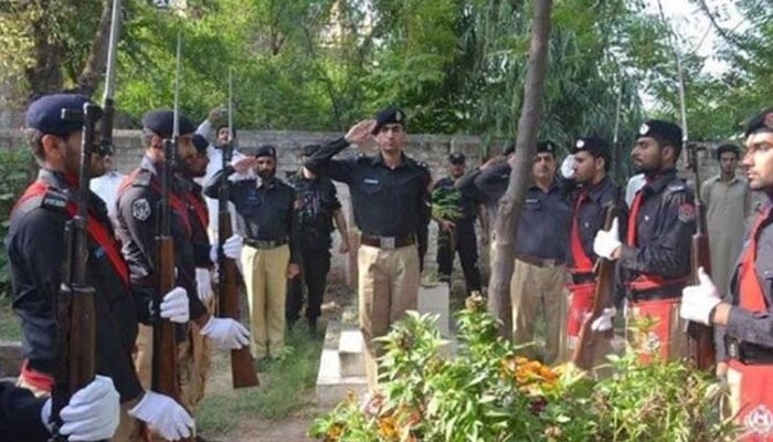 KP policemen saluting at the grave of Martyrs Hero on the occasion of Martyrs Day. — APP/file