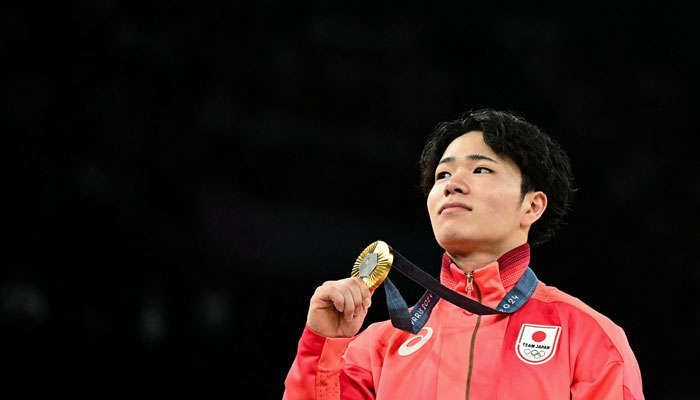 Japans Shinnosuke Oka poses with his gold medal during the podium ceremony for the artistic gymnastics mens horizontal bar event of the Paris 2024 Olympic Games in Paris, on August 5, 2024. — AFP