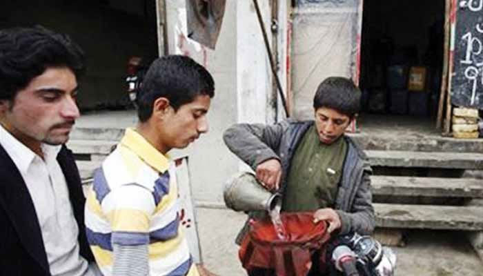 A representational image showing a child transferring smuggled petrol to a container for customers. — APP/File