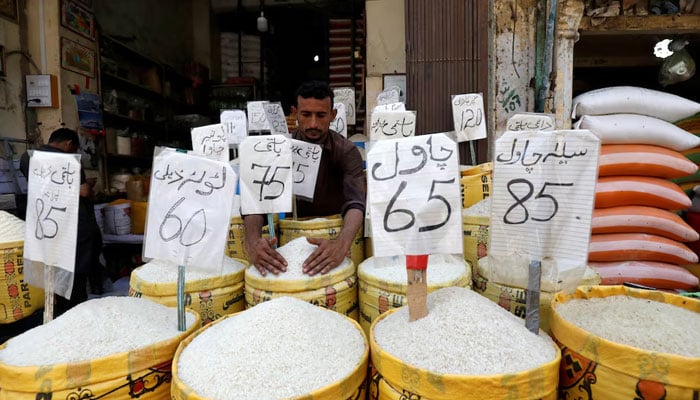 A vendor arranges different types of rice, with their prices displayed, at his shop in a wholesale market in Karachi on April 2, 2019. — Reuters