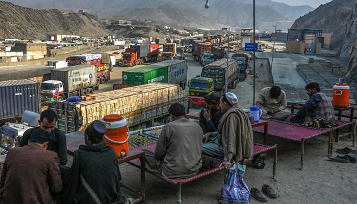 Drivers take a rest as stranded trucks are pictured near the Pakistan-Afghanistan border in Torkham on January 16, 2024. — AFP