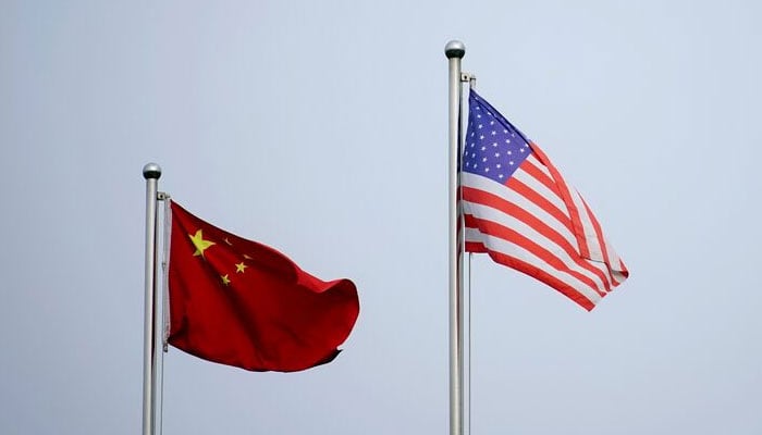 Chinese and U.S. flags flutter outside a company building in Shanghai, China April 14, 2021. — Reuters