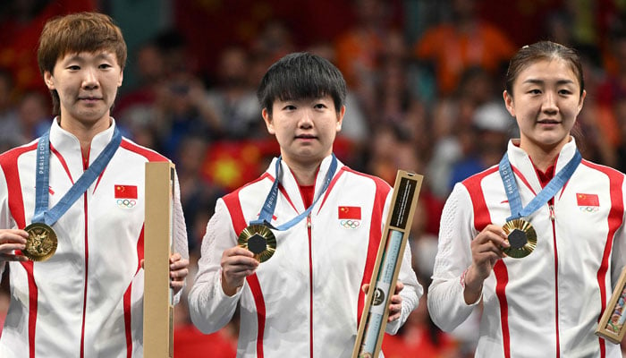 Chinas gold medallists Wang Manyu (L), Sun Yingsha (centre) and Chinas Chen Meng celebrate on the podium of the table tennis team match at the Paris 2024 Olympic Games in Paris on August 10, 2024. — AFP