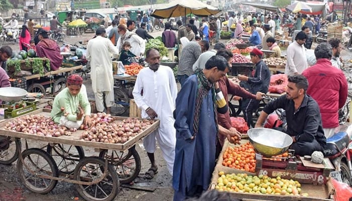 Vendors are selling vegetables at a market in Lahore on March 26, 2023. — Online