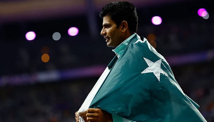 Arshad Nadeem poses with the national flag after winning the gold medal in the Mens Javelin Throw final event in Paris Olympics 2024 at Stade de France, Saint-Denis, France on August 08, 2024. — Reuters