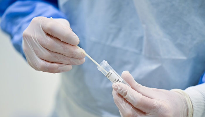 A representational image showing a medical progessional holding a testing swab. — AFP/File