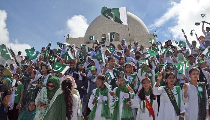 Students wave national flags at the mausoleum of the Quaid-i-Azam Muhammad Ali Jinnah during a ceremony to mark the country’s Independence Day. — Online/File