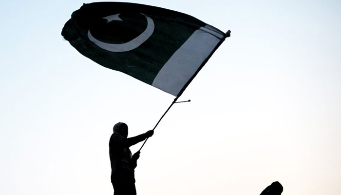 A representational image showing a person waiving the flag of Pakistan. — AFP/File