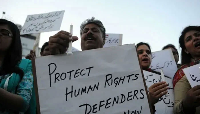 Protesters hold placards highlighting the need to uphold human rights and human rights workers. — AFP/File