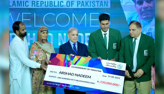 Prime Minister Muhammad Shehbaz Sharif presents a cheque of Rs.150 million to Mr Arshad Nadeem for winning gold medal in Javelin throw at Paris Olympics 2024 on August 13, 2024. — APP