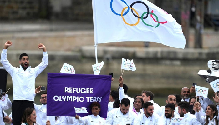 Athletes of the Olympic refugee team react during a Paris Olympics 2024 parade at River Seine on July 26, 2024. — Reuters