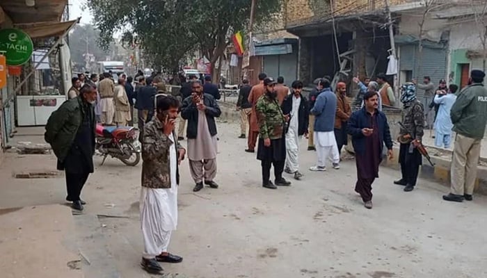 Security personnel and people gather near the site of a bomb explosion at Sibi, in Balochistan province on January 30, 2024. — AFP