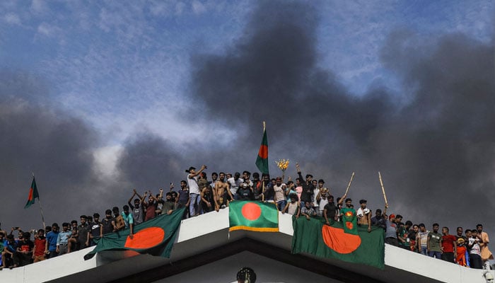 Bangladeshi nationals temporarily residing in India distribute sweets among themselves reacting to the resignation of Bangladesh prime minister Sheikh Hasina following anti -government protests, in Kolkata on August 5, 2024. — AFP