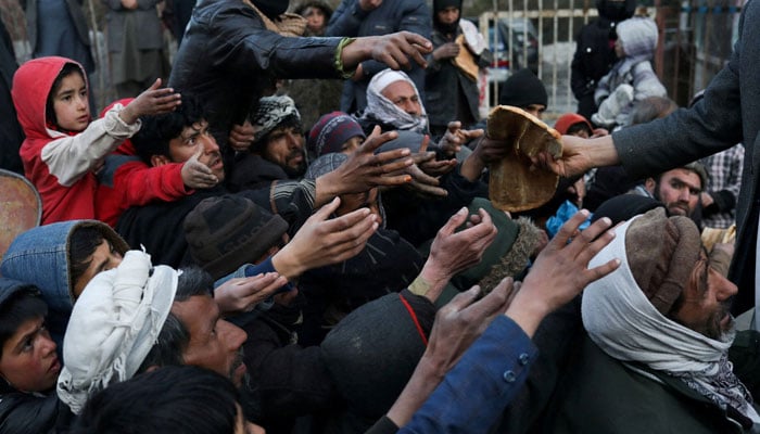 People reach out to receive bread in Kabul, Afghanistan on January 31, 2022. — Reuters